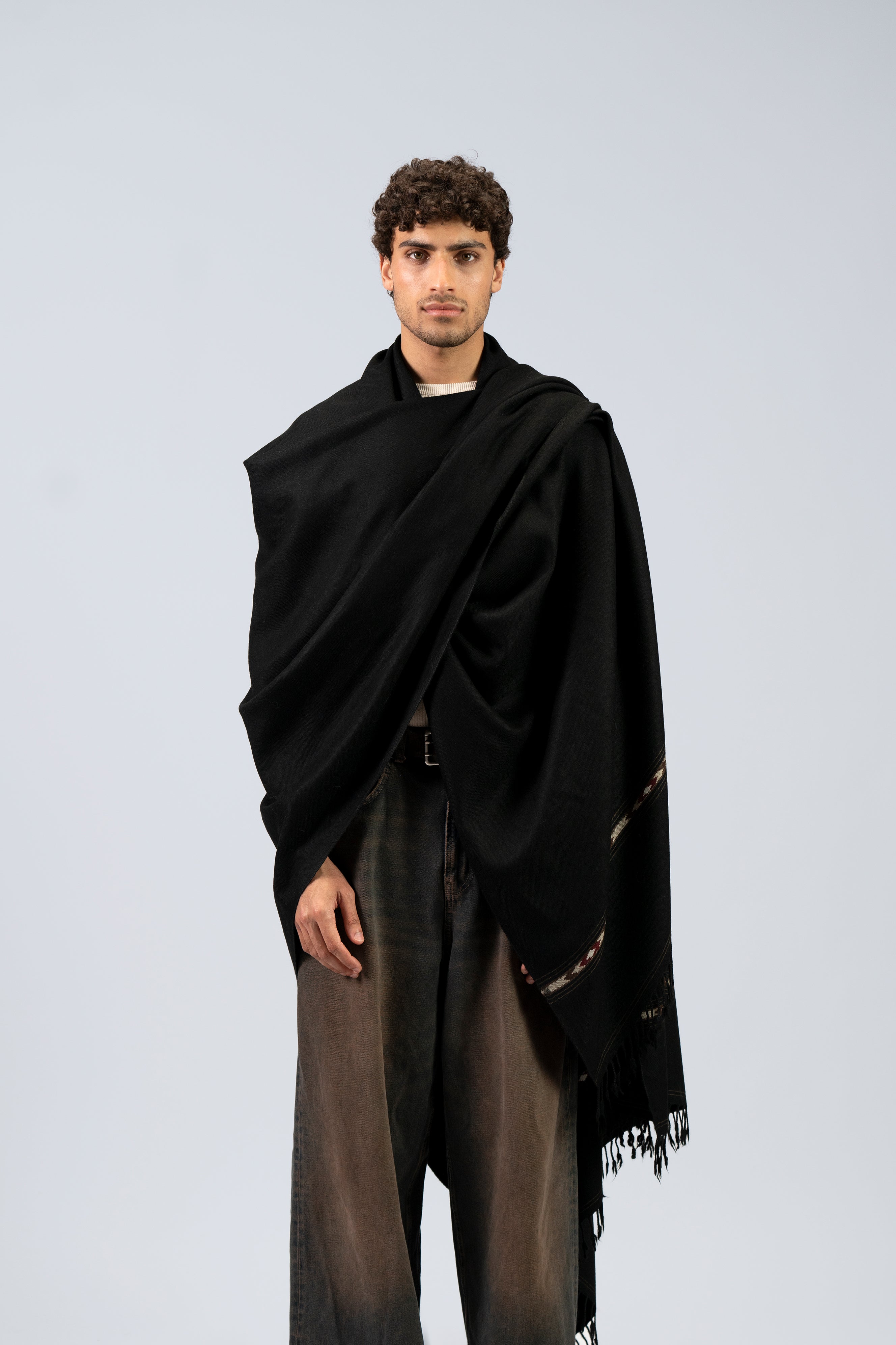 Black handwoven blanket scarf worn draped across shoulders