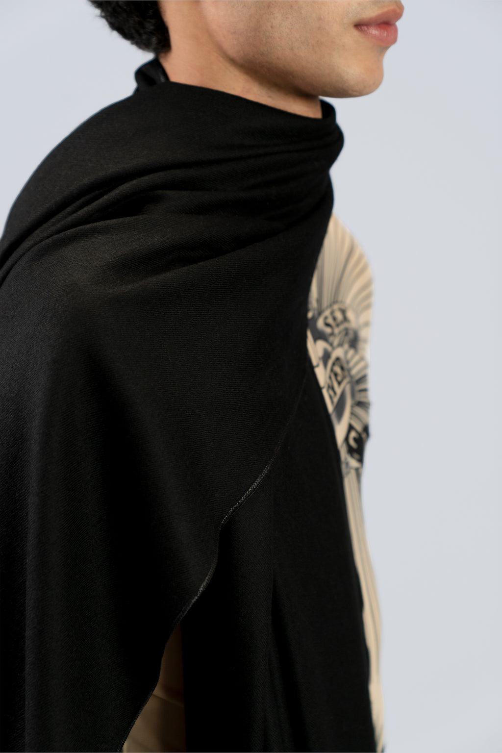 Black heavyweight lamb wool shawl close-up on male model with tattoo sleeve, side view