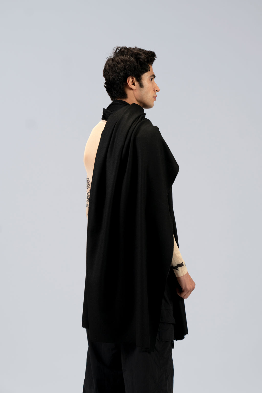Black heavyweight lamb wool shawl from behind on male model with tattoo sleeve, three-quarter back view