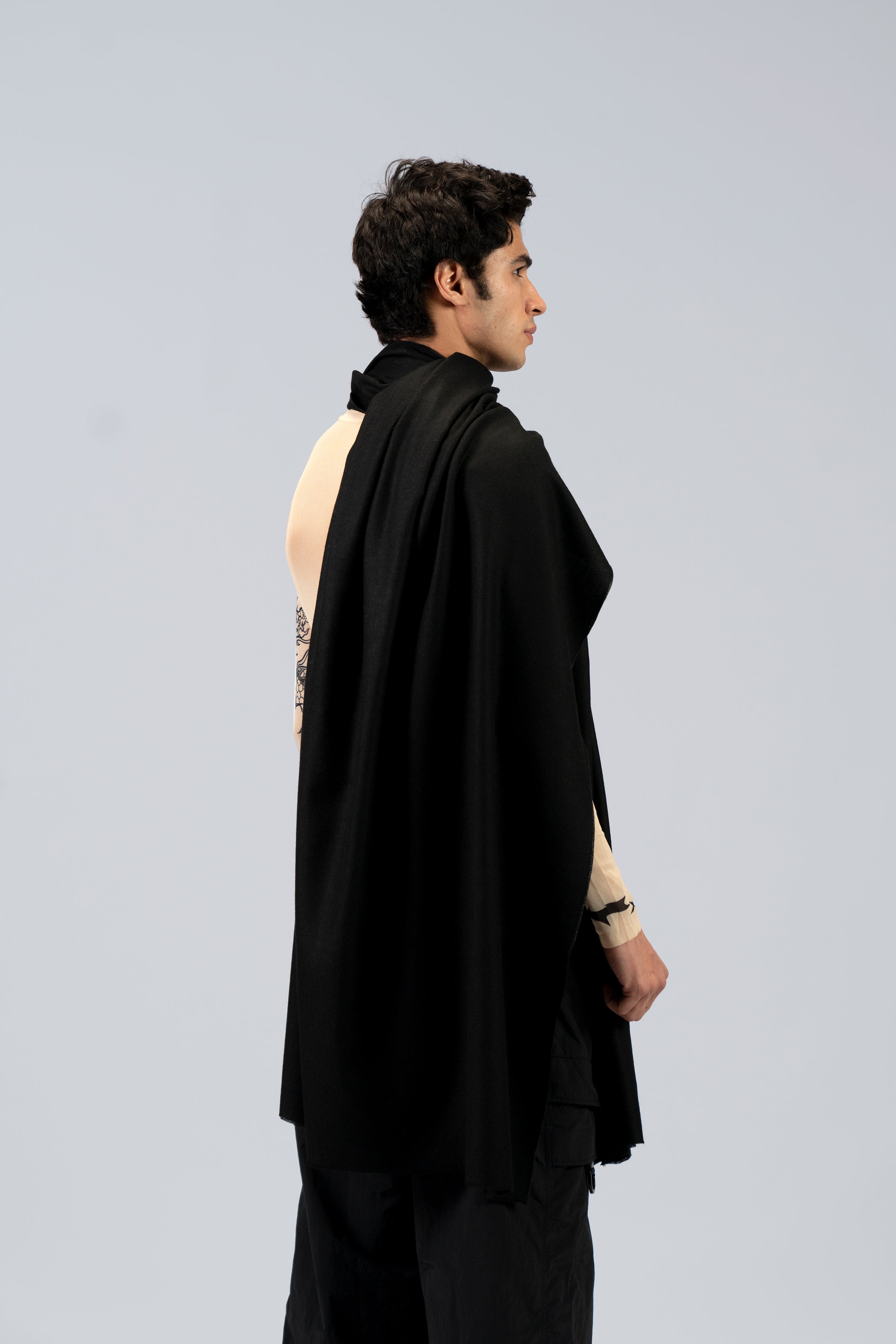 Black heavyweight lamb wool shawl from behind on male model with tattoo sleeve, three-quarter back view