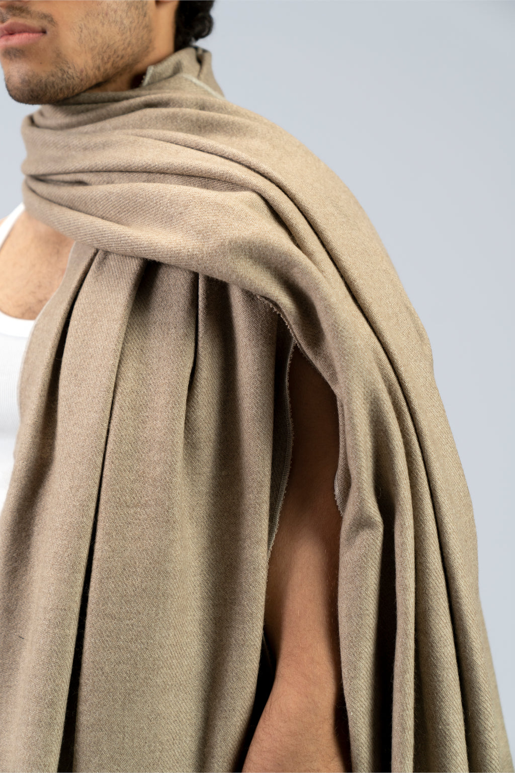 Beige heavyweight lamb wool shawl mid-body close-up showing drape over shoulder