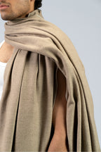 Beige heavyweight lamb wool shawl mid-body close-up showing drape over shoulder