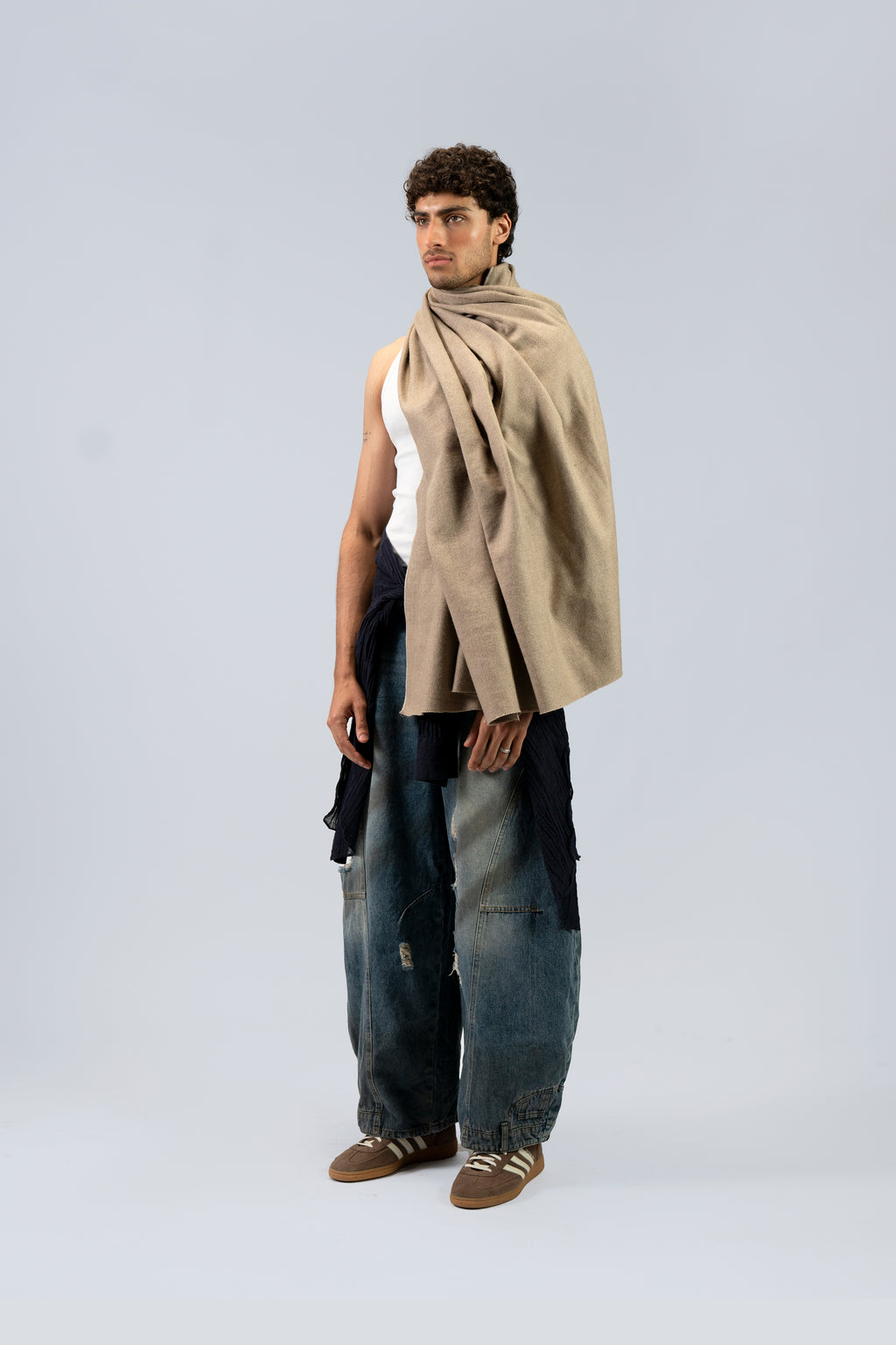 Beige heavyweight lamb wool shawl draped over male model, full-length three-quarter view