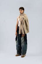 Beige heavyweight lamb wool shawl draped over male model, full-length three-quarter view