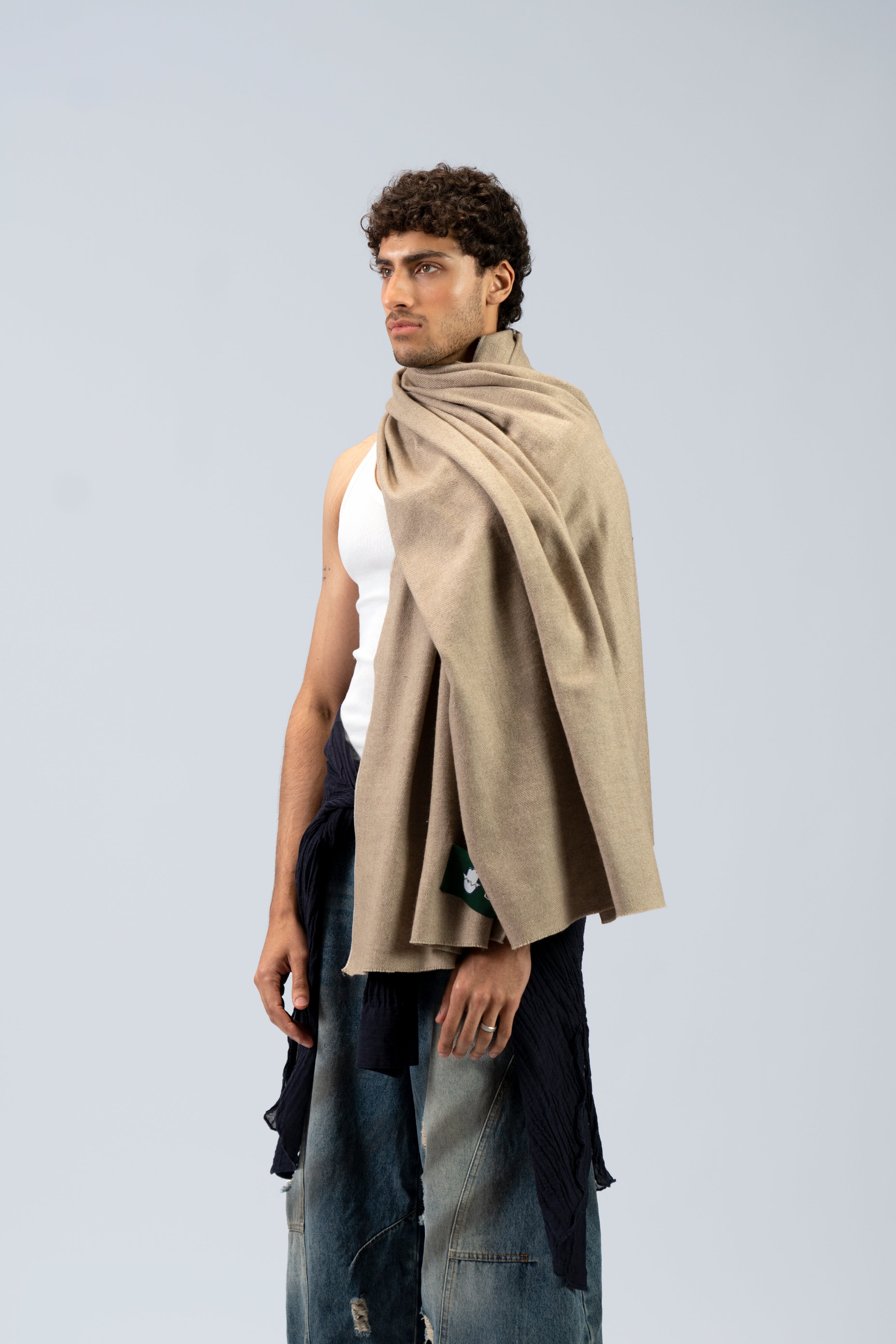 Beige heavyweight lamb wool shawl on male model in tank top, three-quarter side view