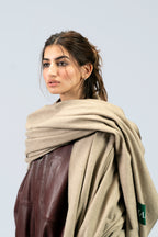 Beige heavyweight lamb wool shawl wrapped at neck on female model, close-up portrait