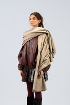Beige heavyweight lamb wool shawl on female model over leather jacket, three-quarter side view