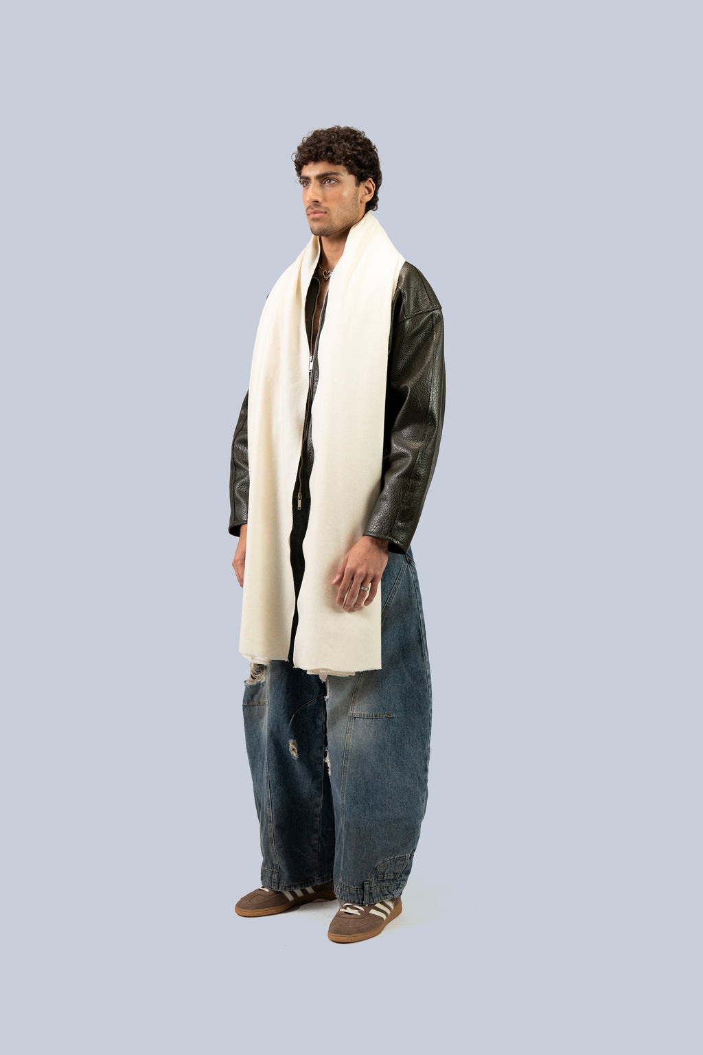 Off-white heavyweight lamb wool shawl draped on male model in leather jacket, full-length three-quarter view