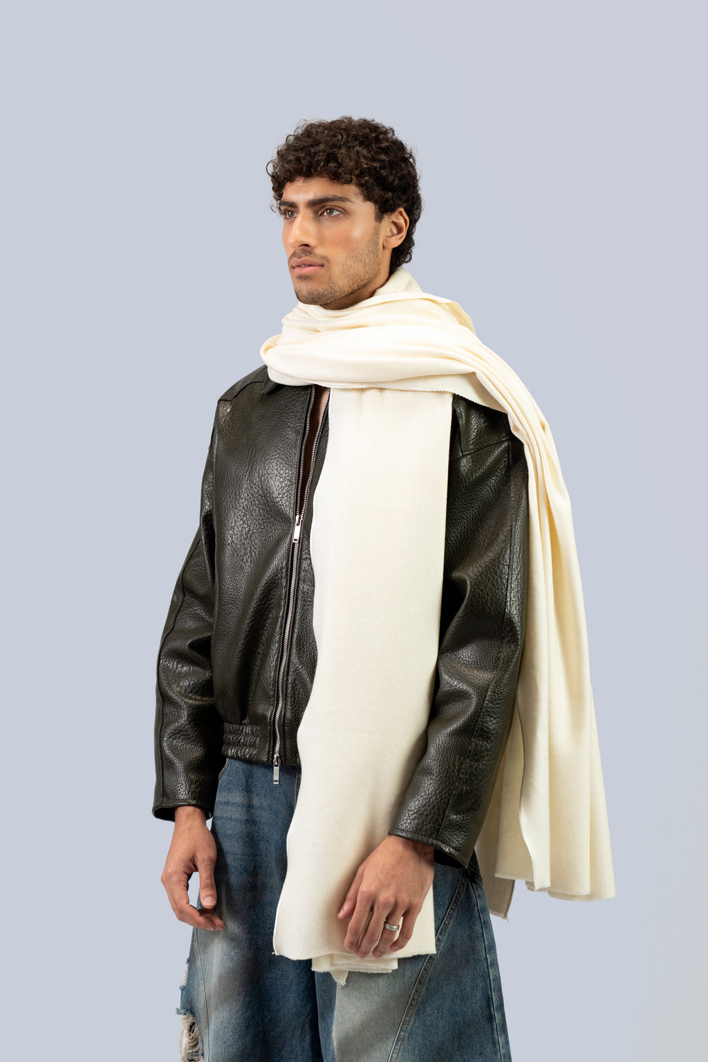 Off-white heavyweight lamb wool shawl over leather jacket on male model, three-quarter side view