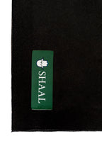 Black heavyweight lamb wool shawl detail of green SHAAL woven label on white background