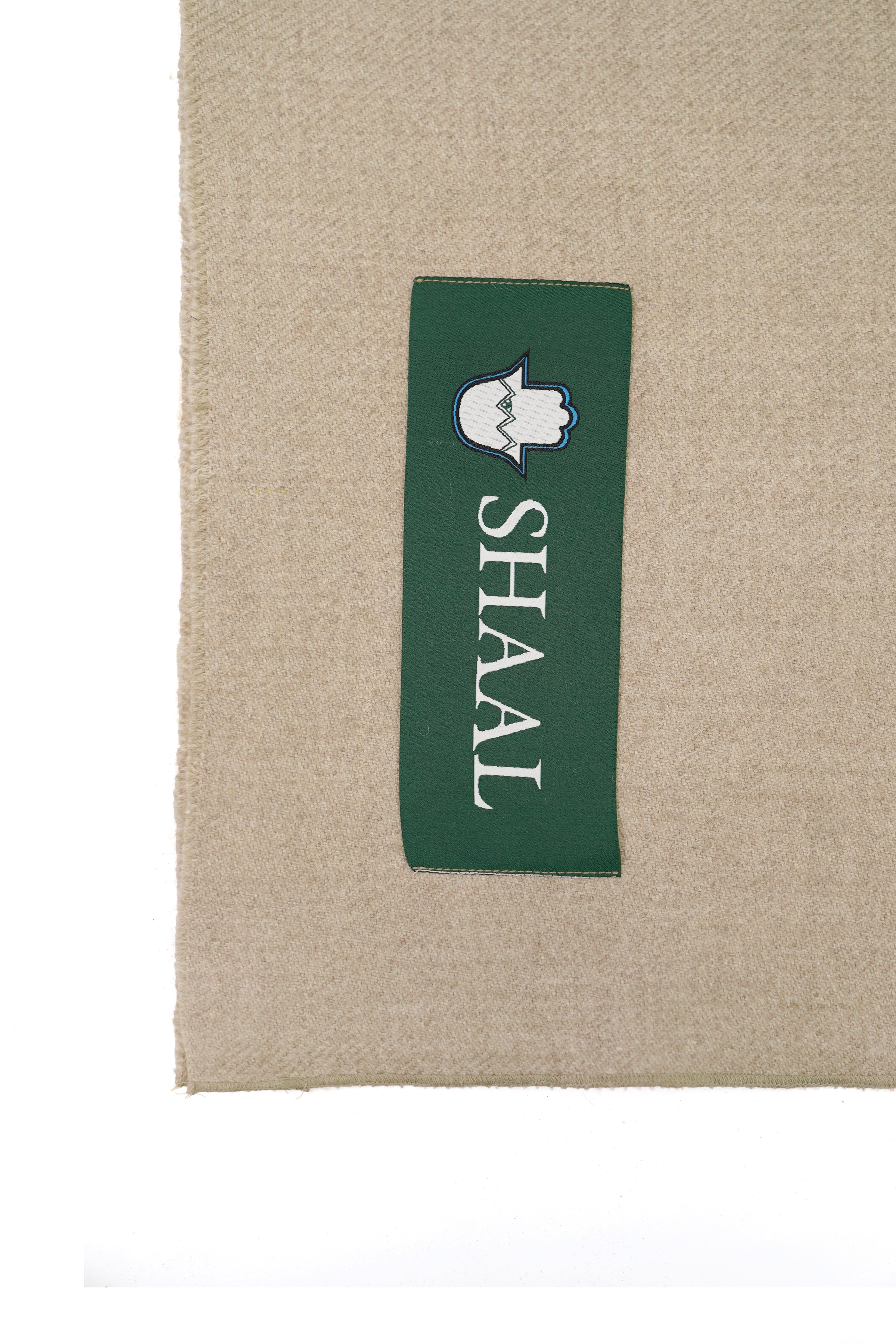 Beige heavyweight lamb wool shawl detail of green SHAAL woven label