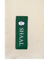 Off-white heavyweight lamb wool shawl detail of green SHAAL label on white background